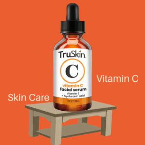 TruSkin Vitamin C Serum bottle on beige wooden table with orange background, highlighting skincare and vitamin C benefits.
