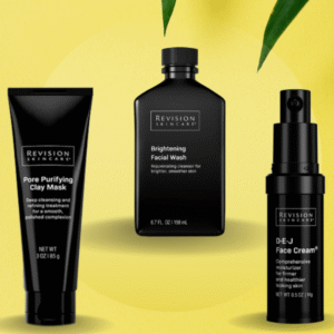 Three black skincare product bottles and a tube are arranged against a yellow background, framed by a few green leaves in the upper portion of the image.